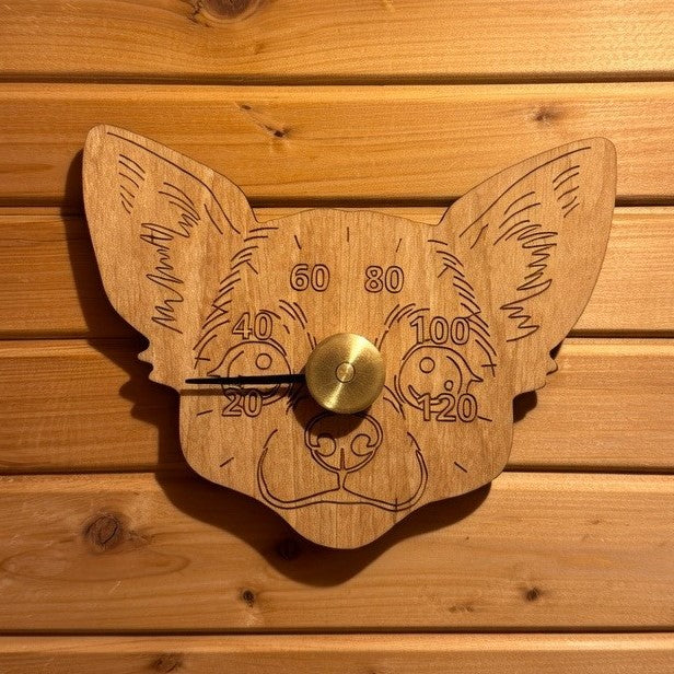 Saunamittari saunan seinällä, joka on Chihuahua koiran pään muotoinen. Tervaleppä löylymittari.